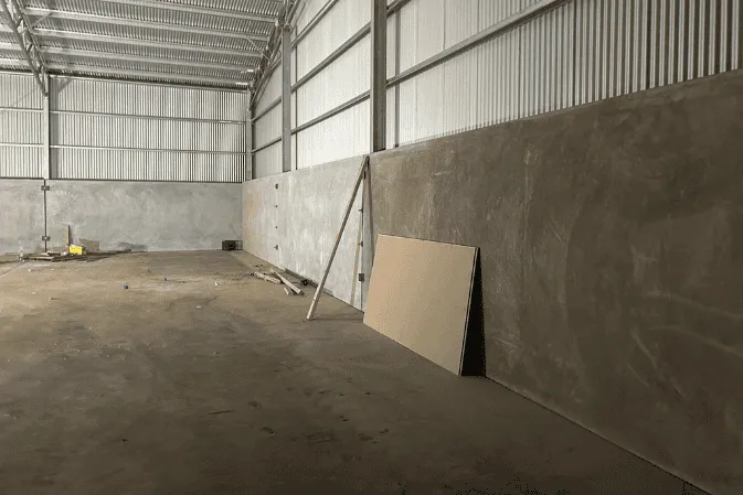 Inside a shed lined with precast tilt panels on a concrete floor