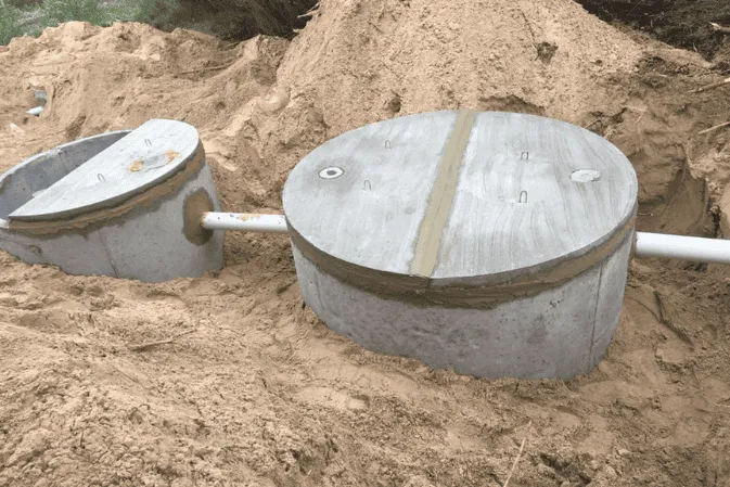 Two precast concrete septic tanks joined by a pipe