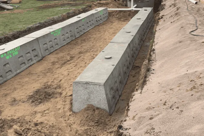 Precast concrete T blocks set in a row in a trench