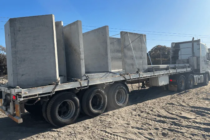 Large precast concrete units loaded upright on a semi-trailer